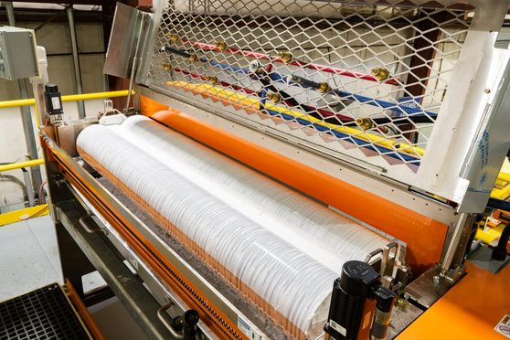 IMC glue coating station applying adhesive at the roll applicator